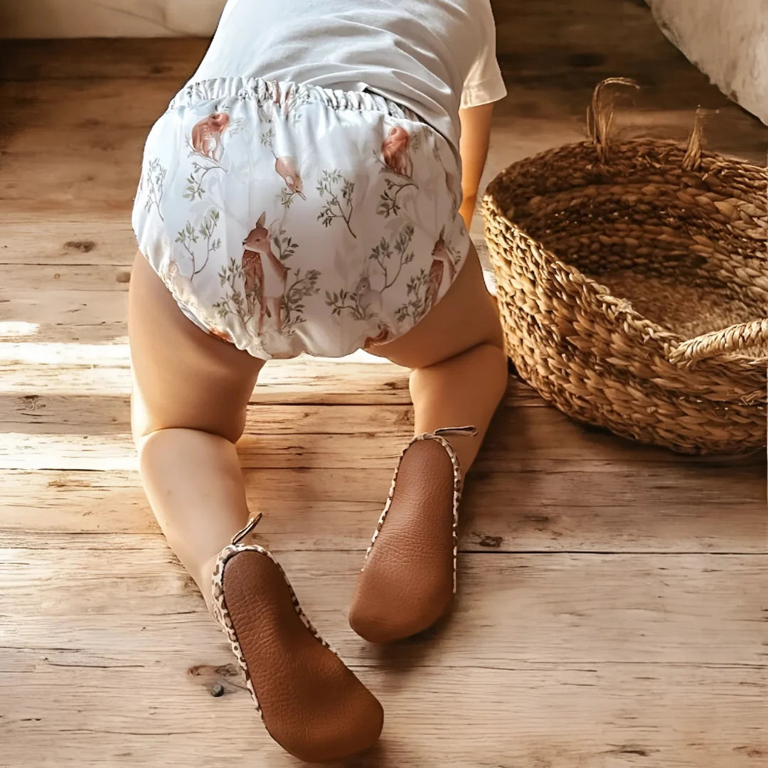 Enfant de dos portant une culotte d'apprentissage Presque Grand sur parquet en bois